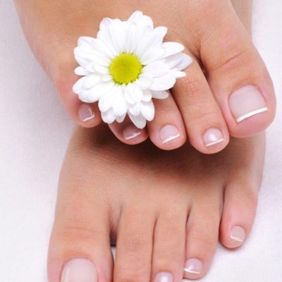 beauty-care-female-feet-with-camomile-s-flower