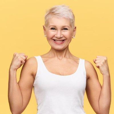 people-age-well-being-health-concept-attractive-stylish-mature-female-wearing-white-tank-top-showing-her-muscled-arms-clenching-fists-smiling-broadly-having-happy-energetic-look