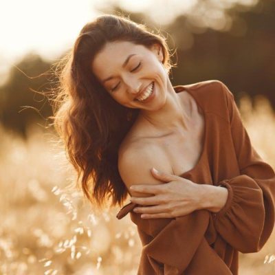 woman-summer-field-brunette-brown-sweater